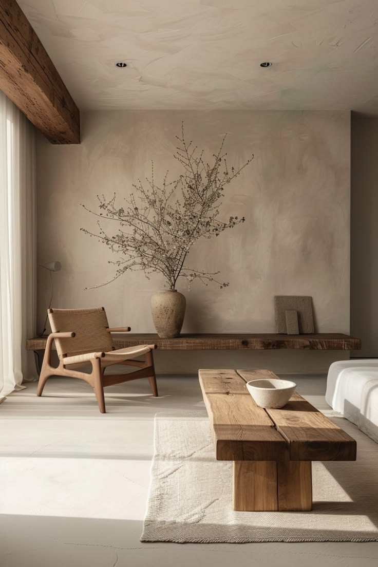 Salón con muro de mortero continuo, banco de madera maciza y butaca de fibra natural