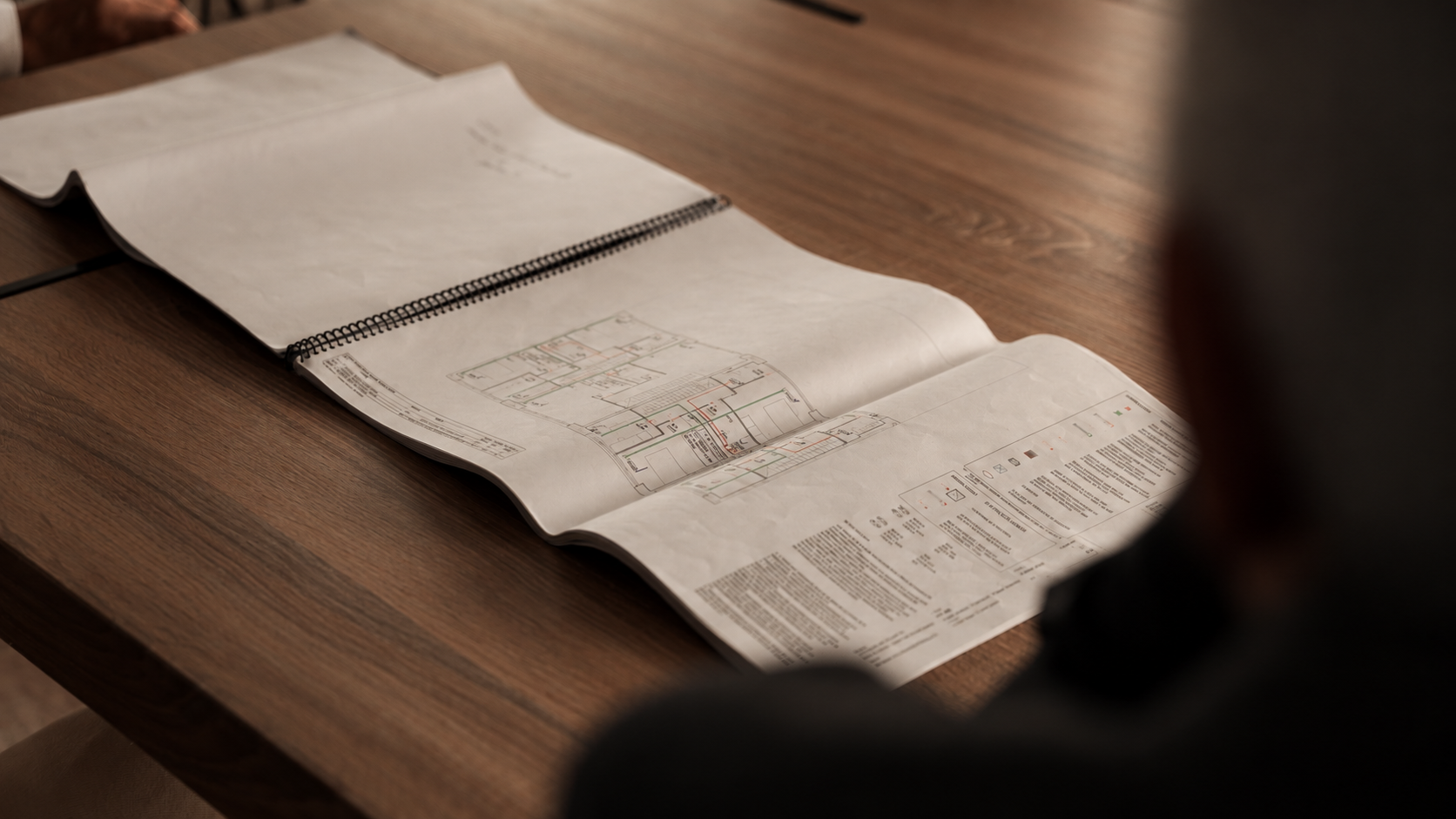 Planos de proyecto desplegados sobre un escritorio de madera