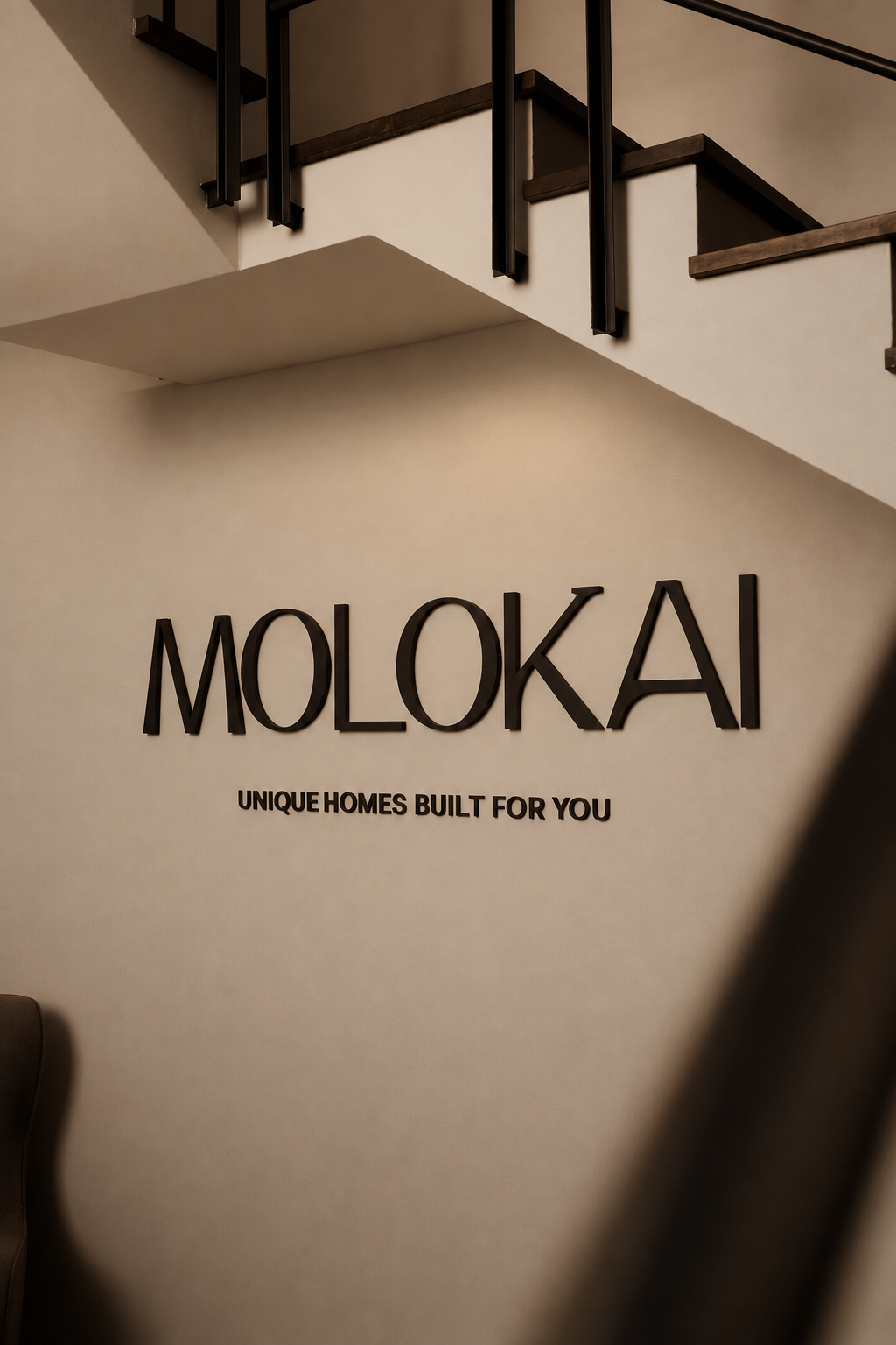 Rótulo MOLOKAI con el lema Unique homes built for you en la pared de la oficina